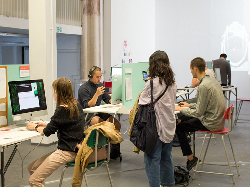  The Experiments in Play exhibition; visitors are milling around the open plan event space and sat at computers trying different games.